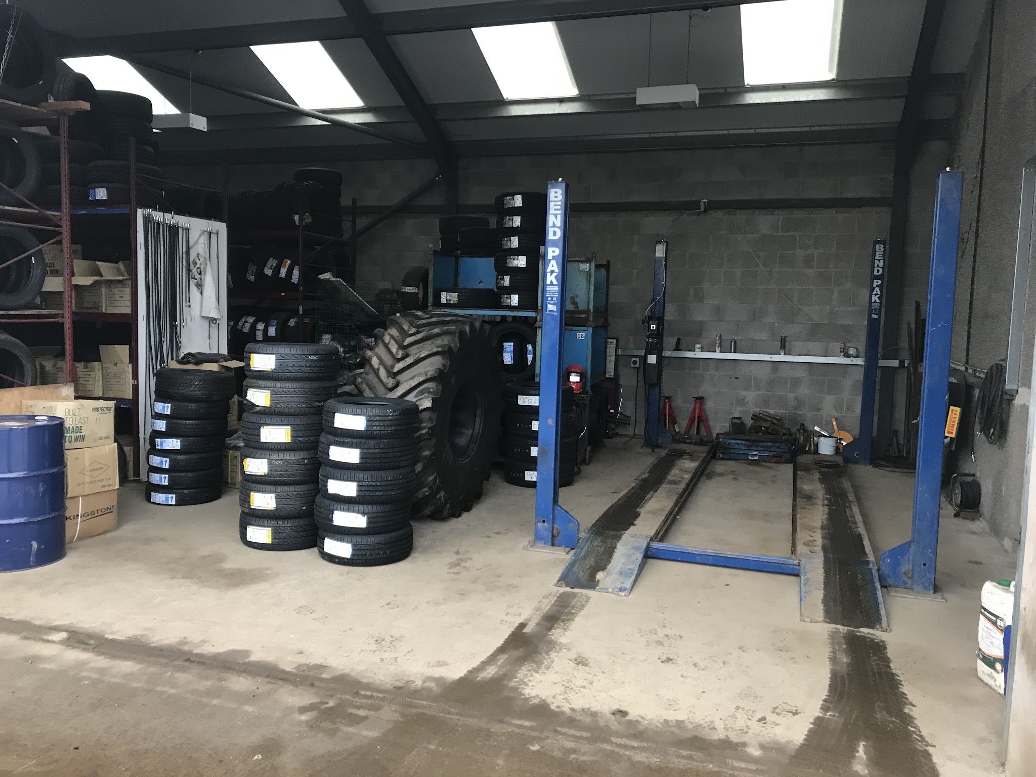 Inside the workshop: tyre machine, ramp and racks of tyres