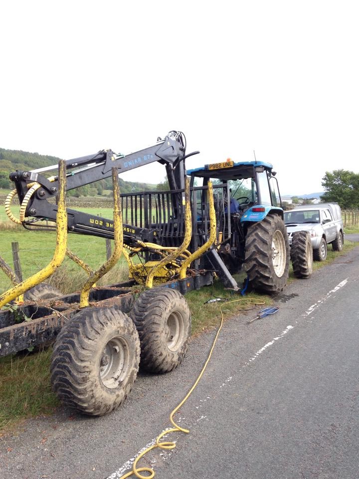 A forestry forwarder having its tyres seen to at the roadside