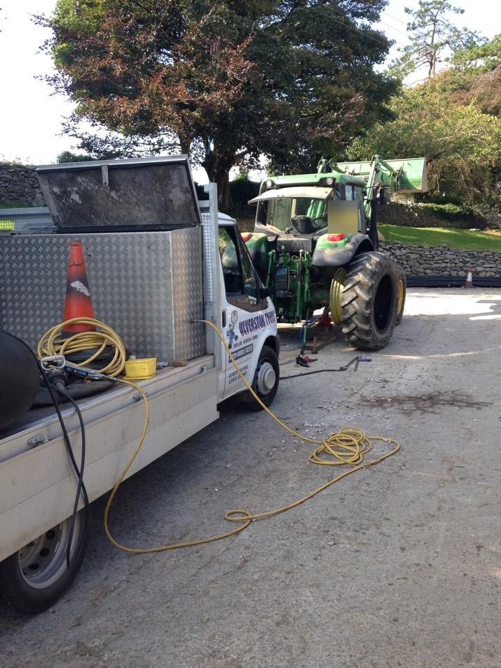 The Ulverston Tyres pickup with its kit out, a green tractor jacked up behind