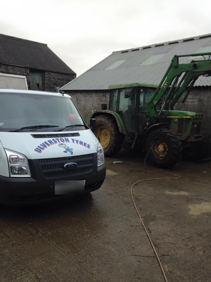 Ulverston Tyres van in a farmyard next to a John Deere tractor