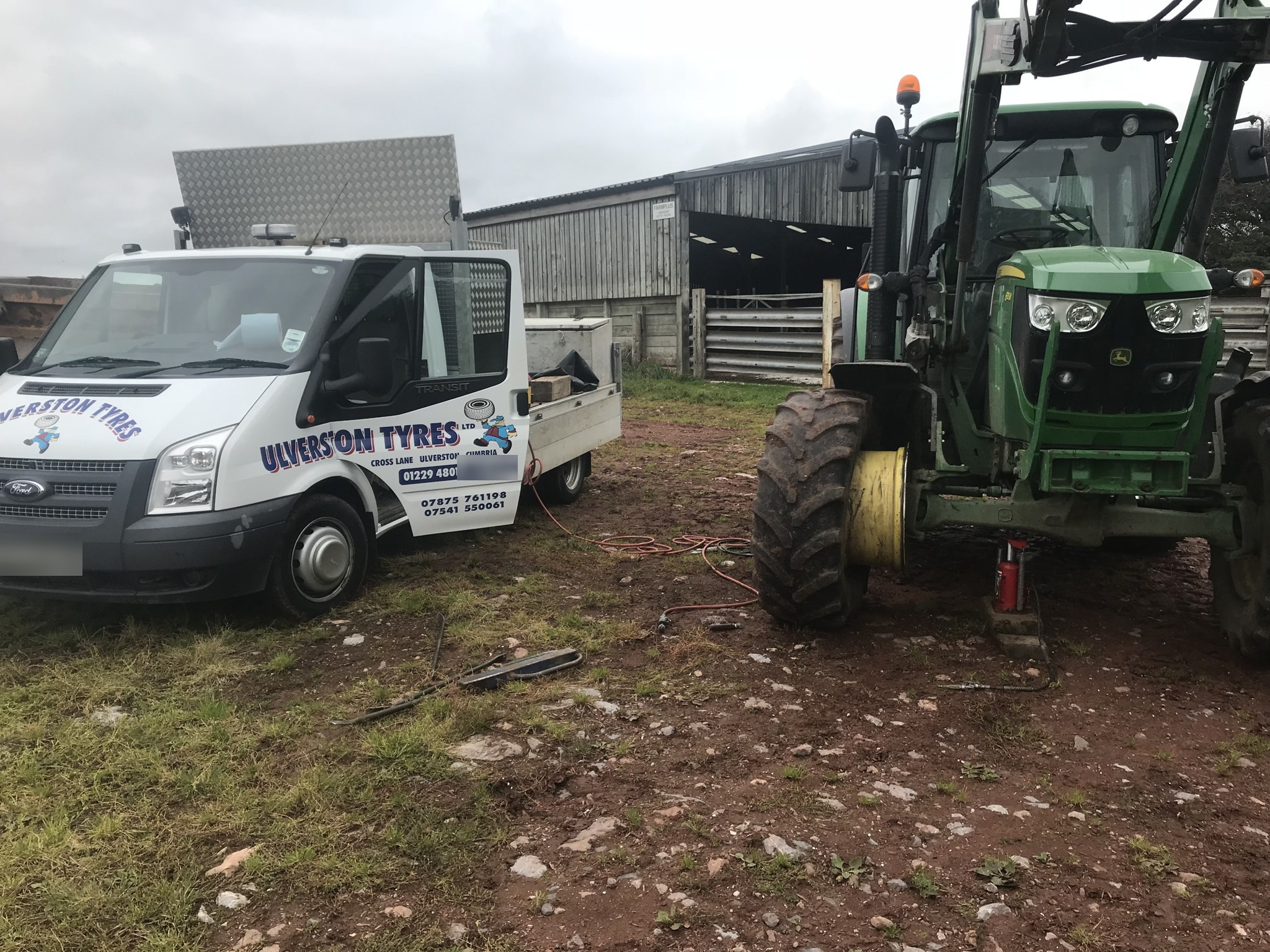 The Ulverston Tyres van beside a John Deere tractor on a farm job